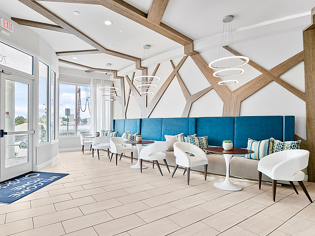 Inviting modern lobby featuring stylish blue accents, elegant circular lighting, and comfortable seating arrangements.