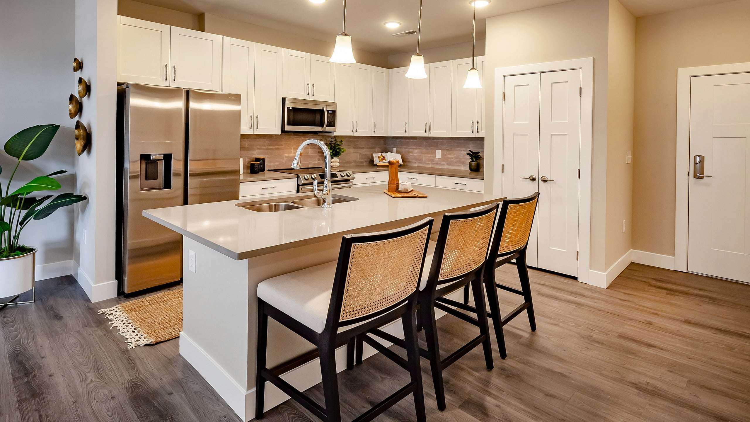 Modern kitchen with sleek white cabinetry, stainless steel appliances, and inviting island seating perfect for entertaining.