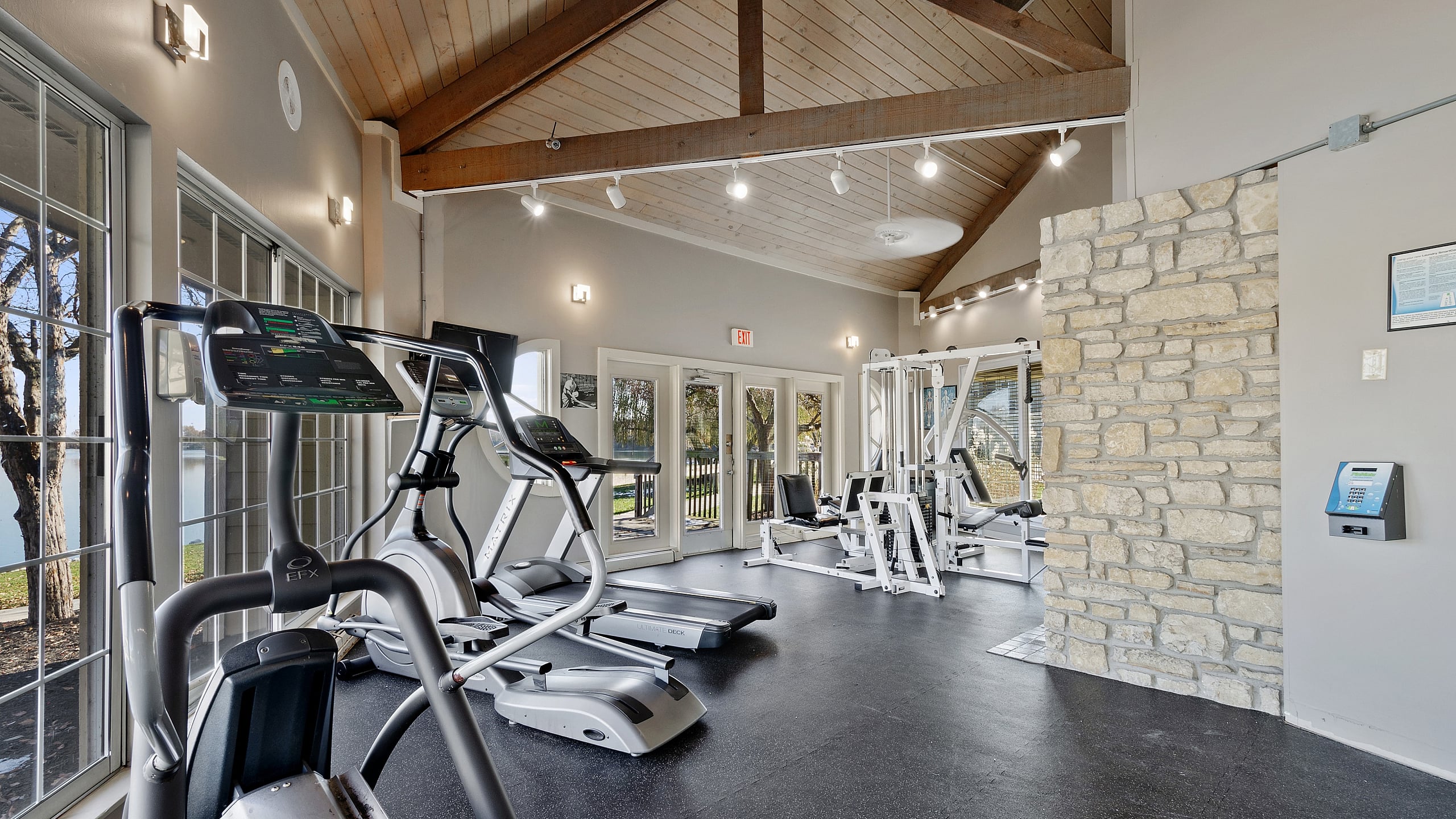 Bright and modern gym with state-of-the-art exercise equipment and expansive windows offering a serene view.