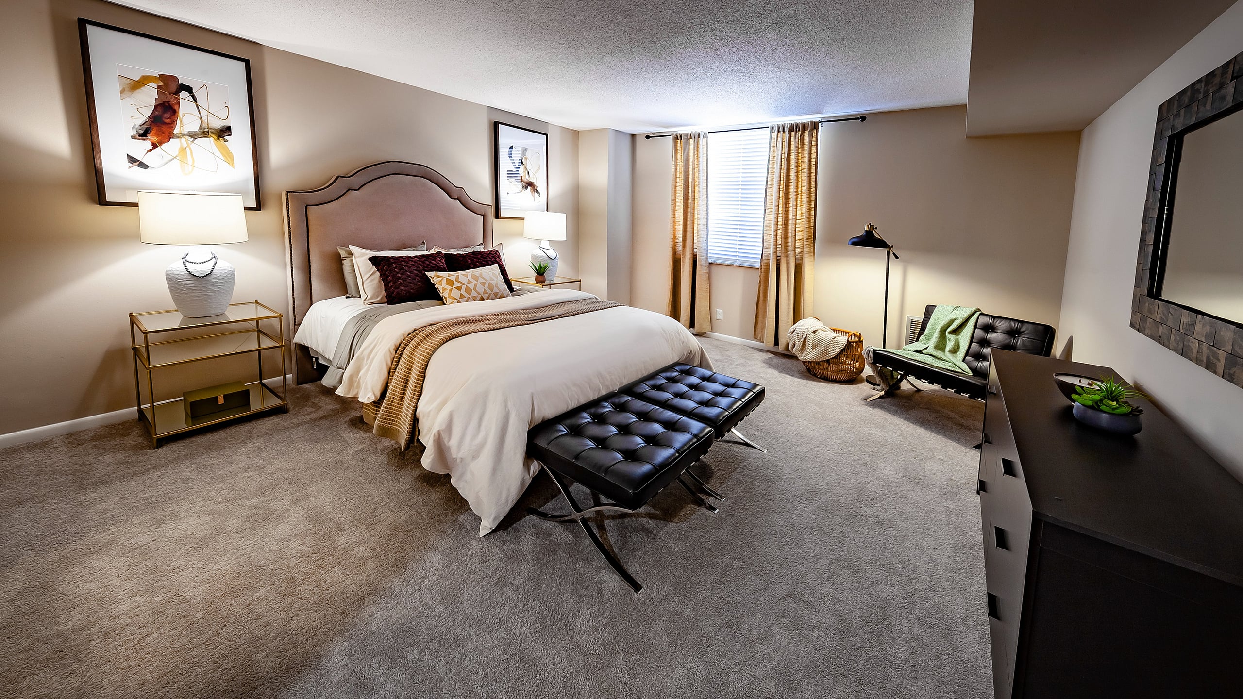 Elegant bedroom with plush carpet, a luxurious queen bed, stylish side tables, chic lamps, and tasteful wall art, creating a serene retreat.
