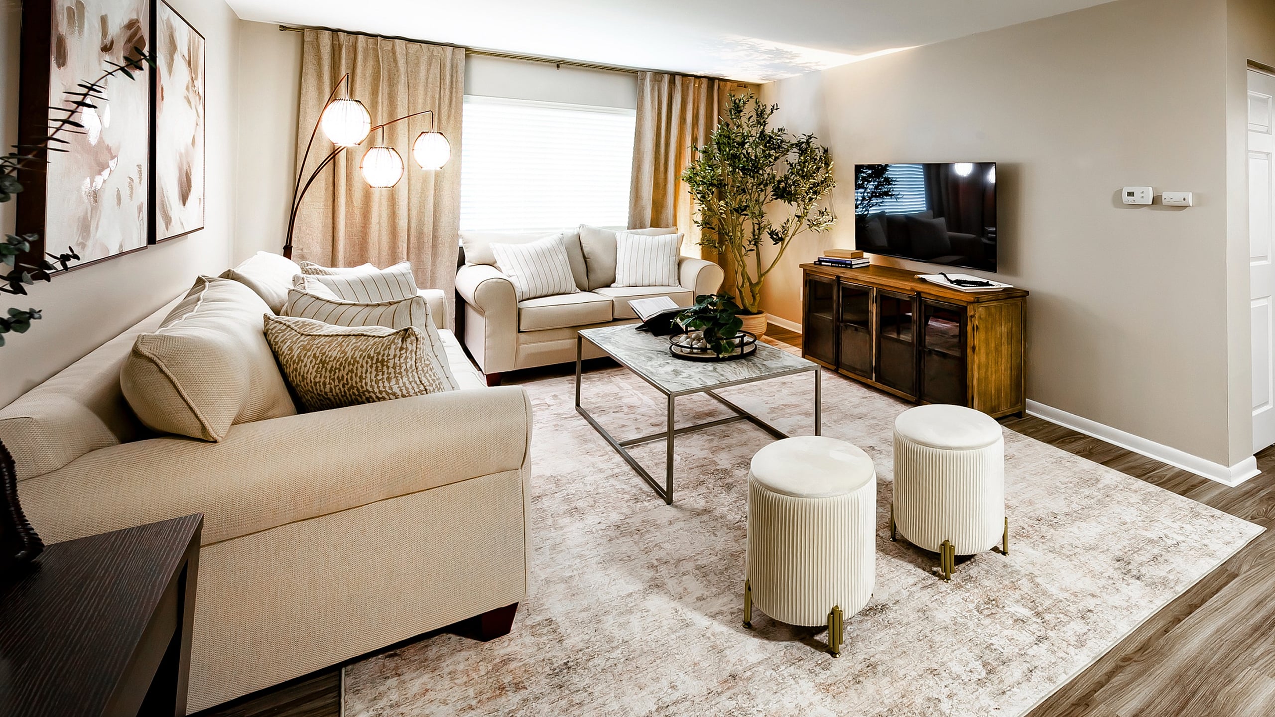Main Street on the Monon Apartment - Inviting living room with elegant beige sofas, stylish coffee table, and modern decor on a chic area rug.