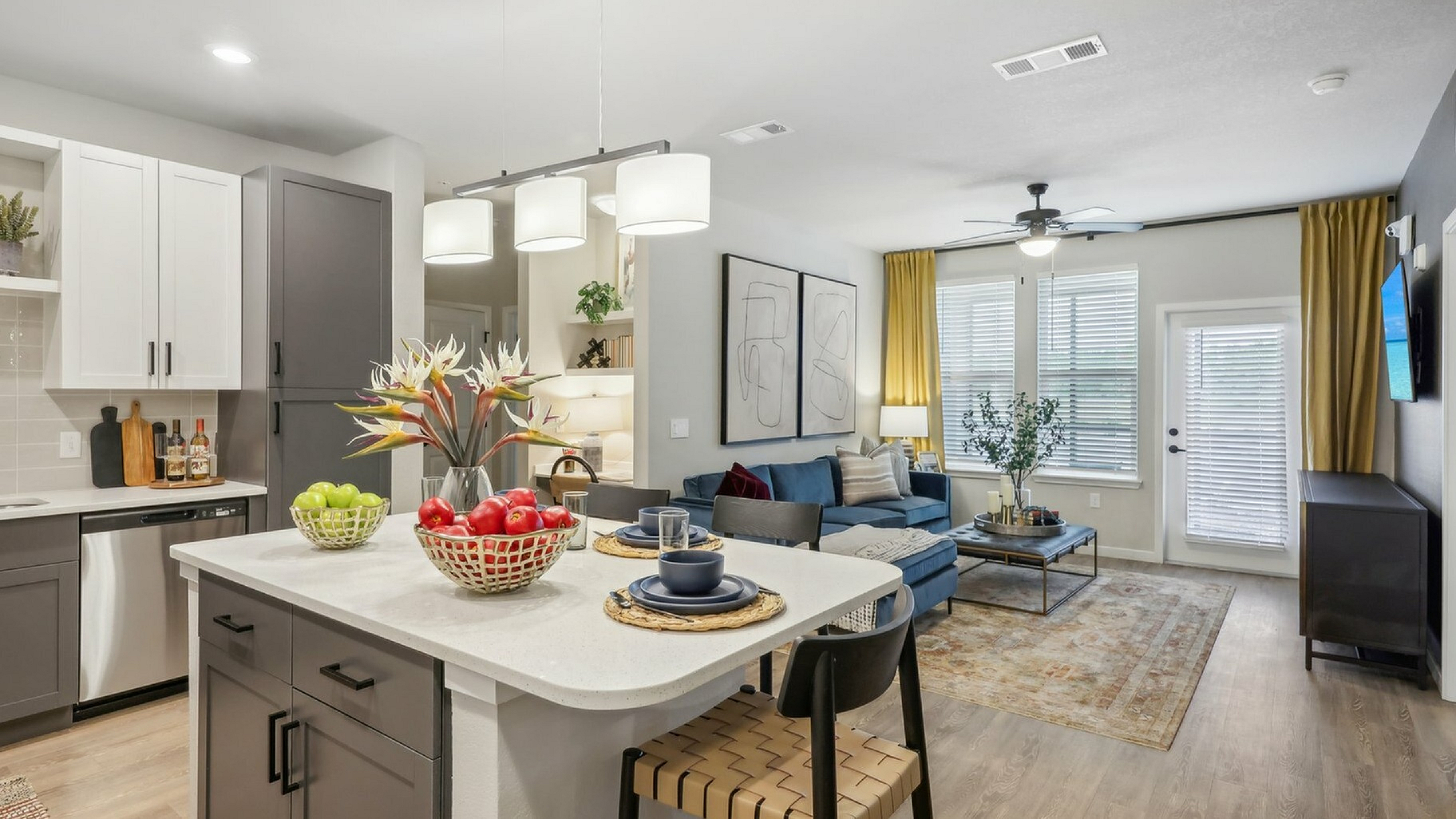 Modern open-concept living space featuring a sleek kitchen with a central island, cozy dining area, and stylish living room with elegant decor.