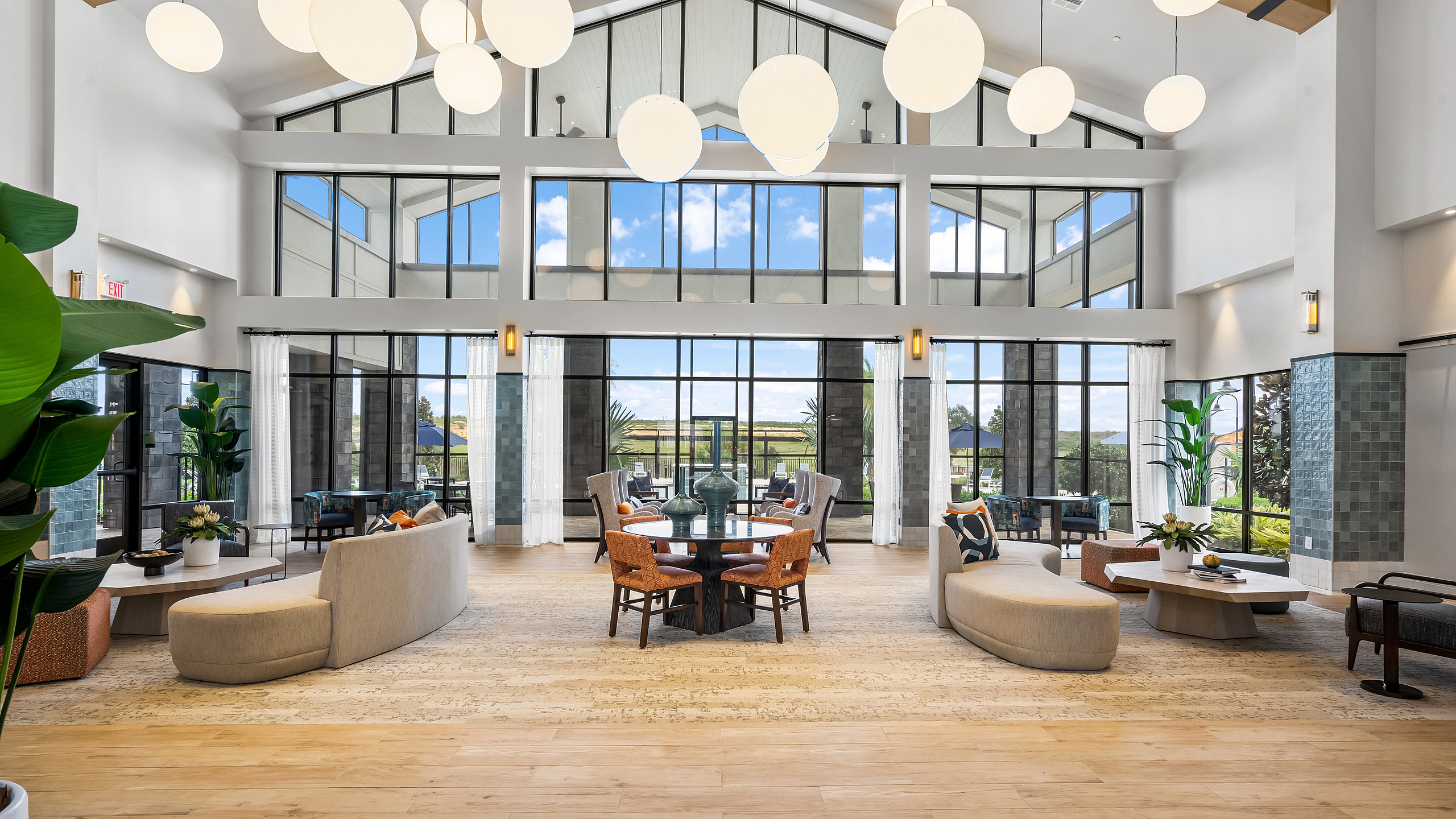 Elegant lounge area with large windows, contemporary furniture, and soft lighting, offering a spacious and welcoming ambiance.