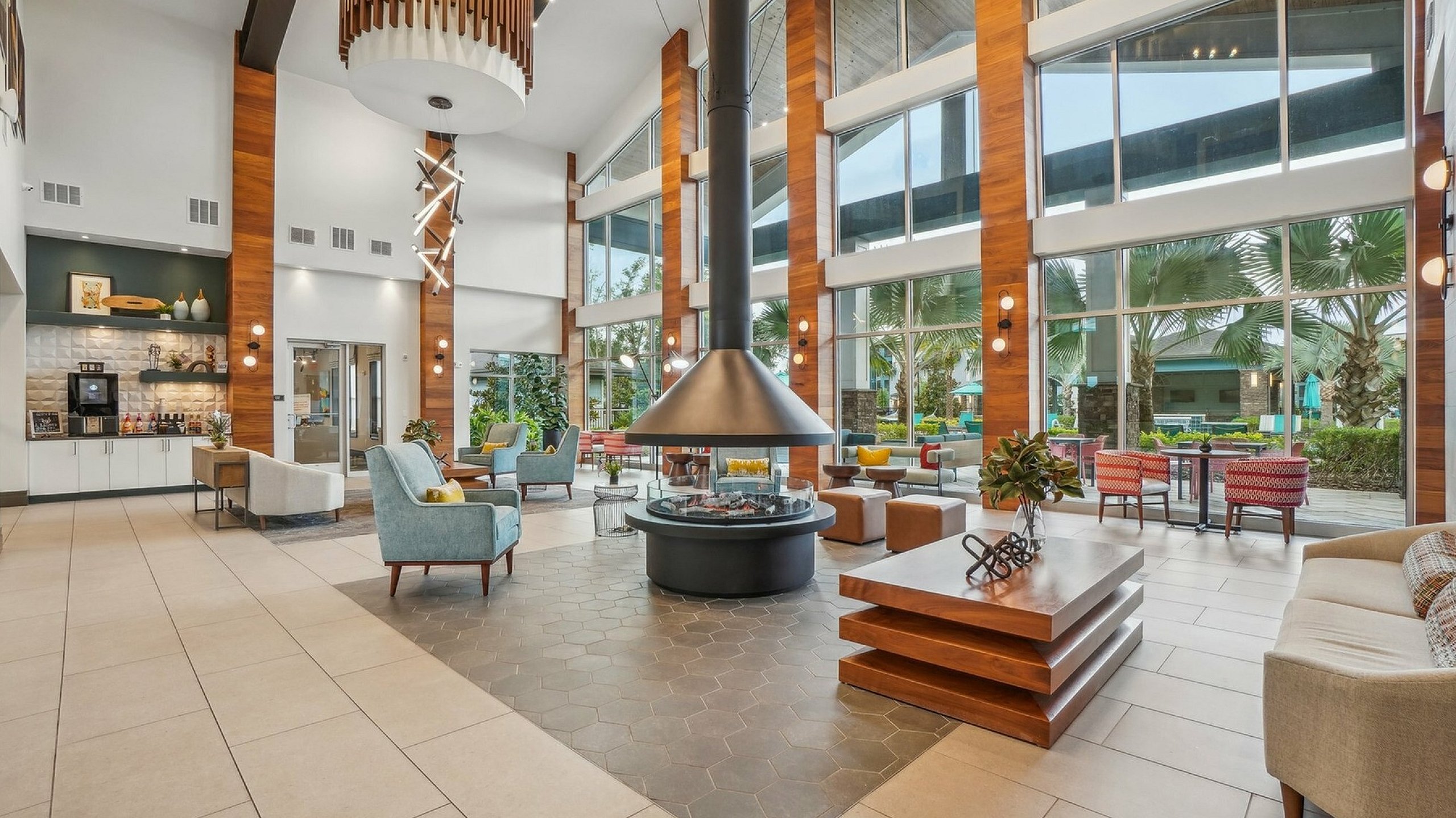 Luxurious open-concept lounge area with modern decor, ample natural light, and expansive windows offering scenic outdoor views.