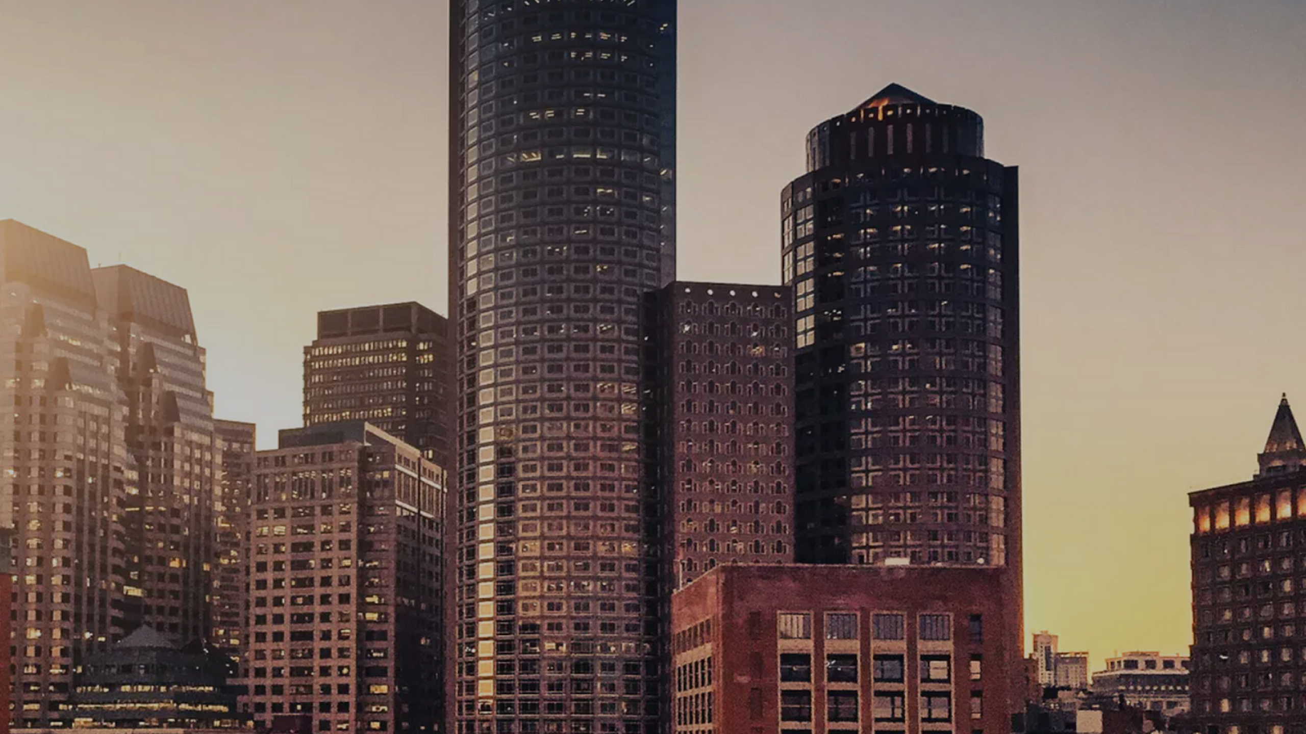 Majestic city skyline at sunset featuring modern high-rise buildings with striking architecture.