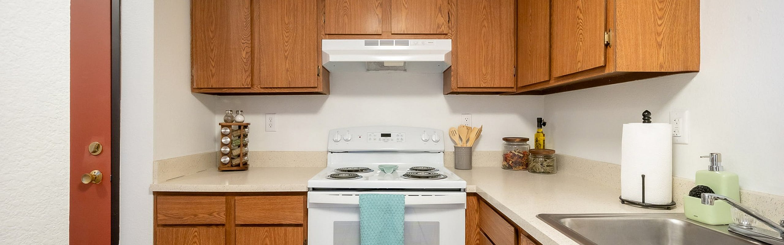Charming kitchen with warm wooden cabinets, modern appliances, and sleek countertops, perfect for culinary creativity.
