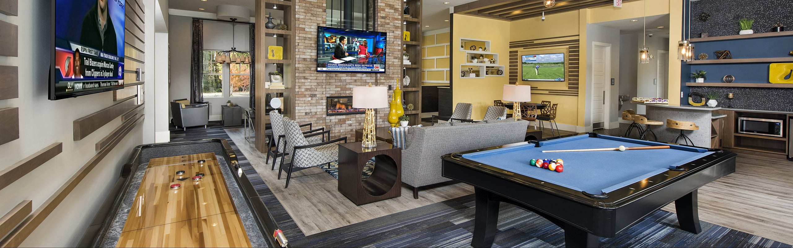 Luxurious entertainment lounge featuring a sleek pool table, modern seating, large TV screens, and stylish decor.