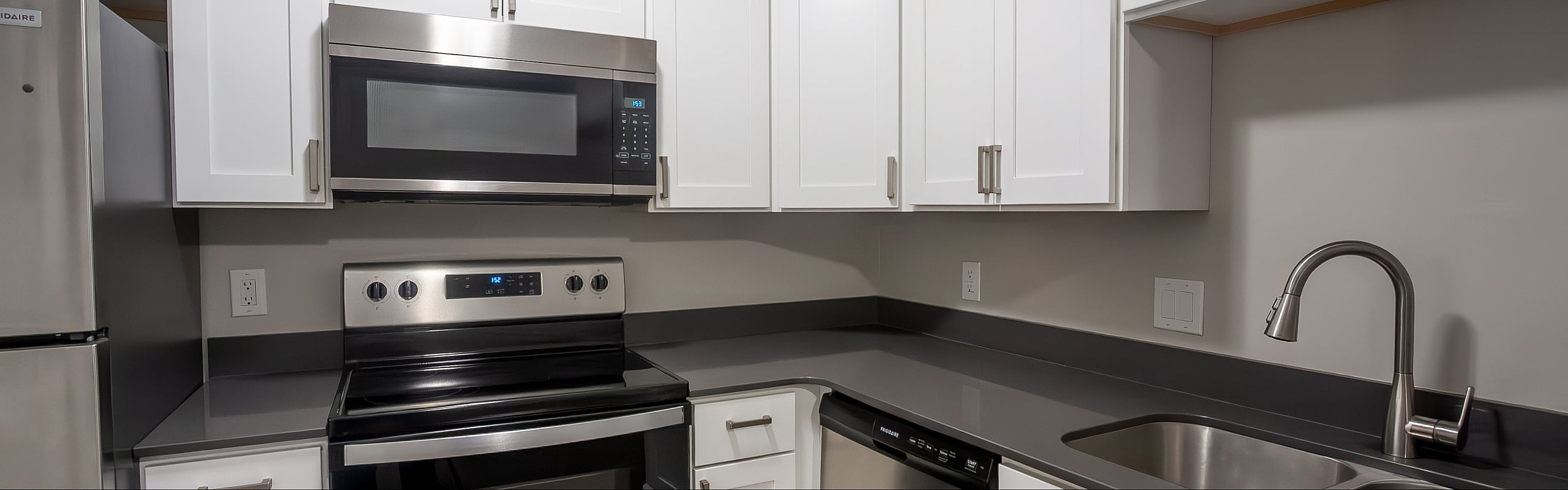 Modern kitchen with stainless steel appliances, sleek countertops, and stylish white cabinetry.
