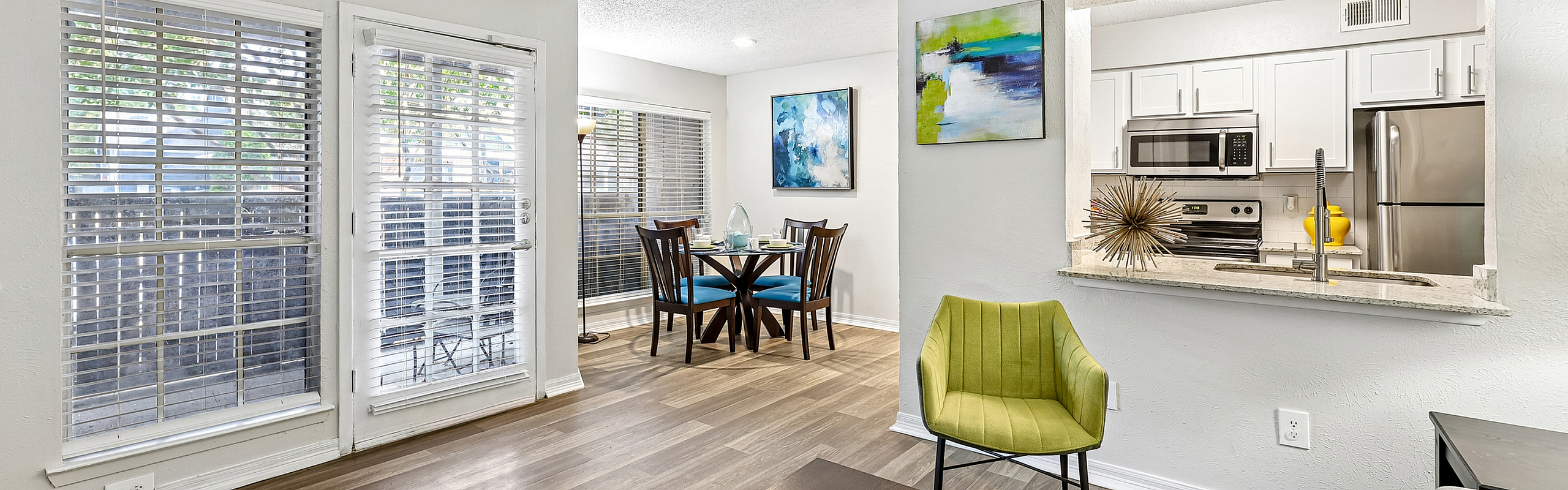 Bright and inviting dining and kitchen area with modern appliances, chic decor, and large windows offering natural light.