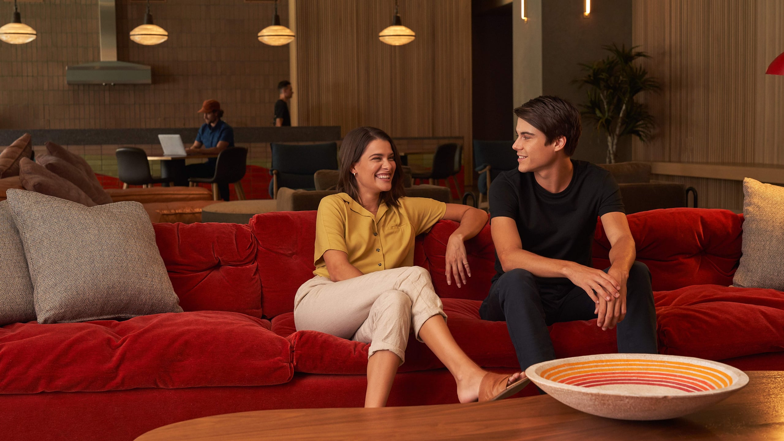 Modern lounge with plush red sofa and inviting ambiance, ideal for relaxation and socializing.