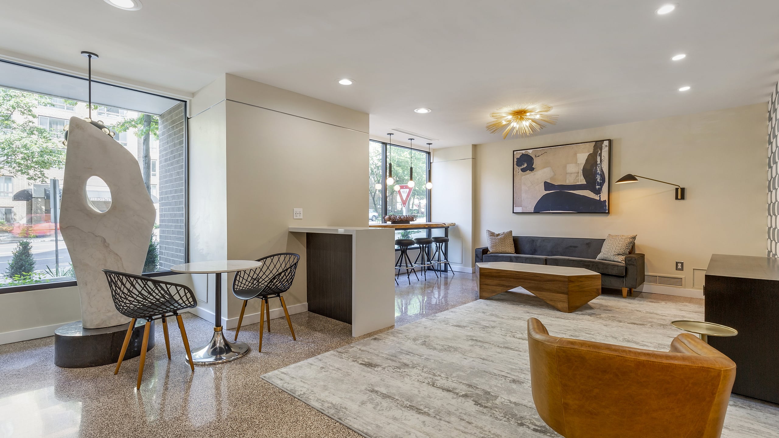 Modern apartment interior with stylish decor, featuring a cozy seating area, elegant dining setup, and large windows for natural light.