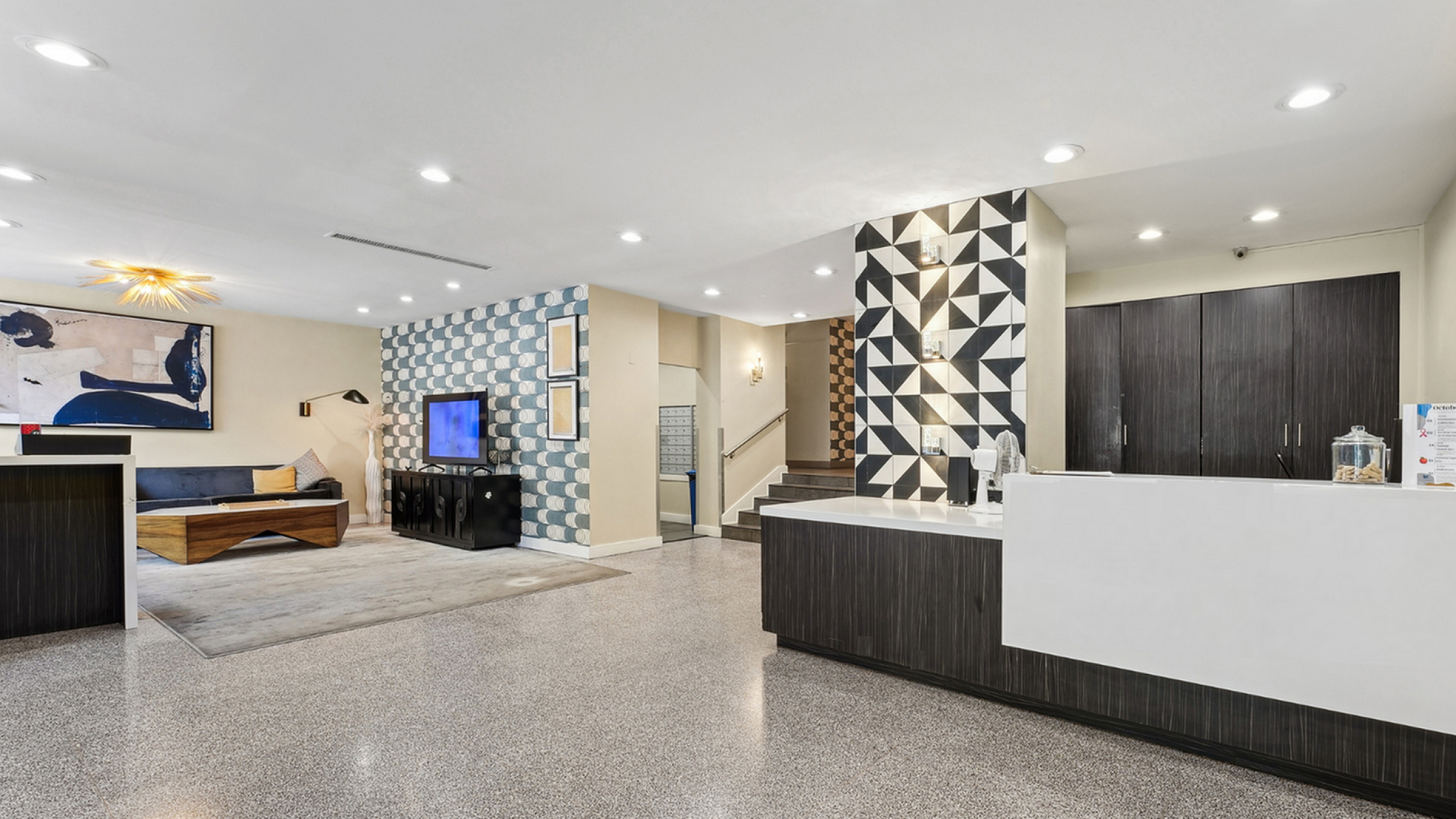 Chic and modern lobby with stylish geometric wall patterns, cozy seating area, and elegant reception desk, creating a welcoming atmosphere.