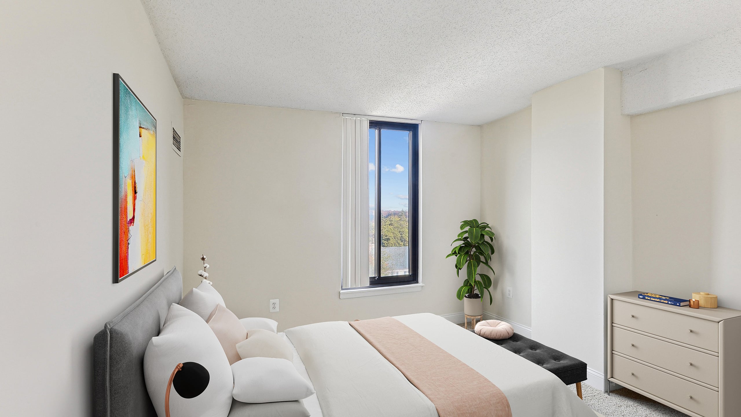 Bright and cozy bedroom with a minimalist design, showcasing a comfortable bed, modern art, and a large window letting in natural light.
