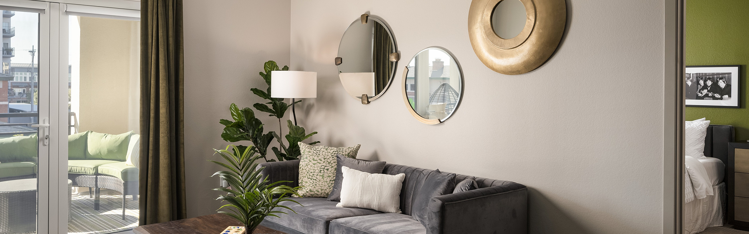 Modern living room with chic decor, plush gray couch, and vibrant balcony view, perfect for stylish urban living.