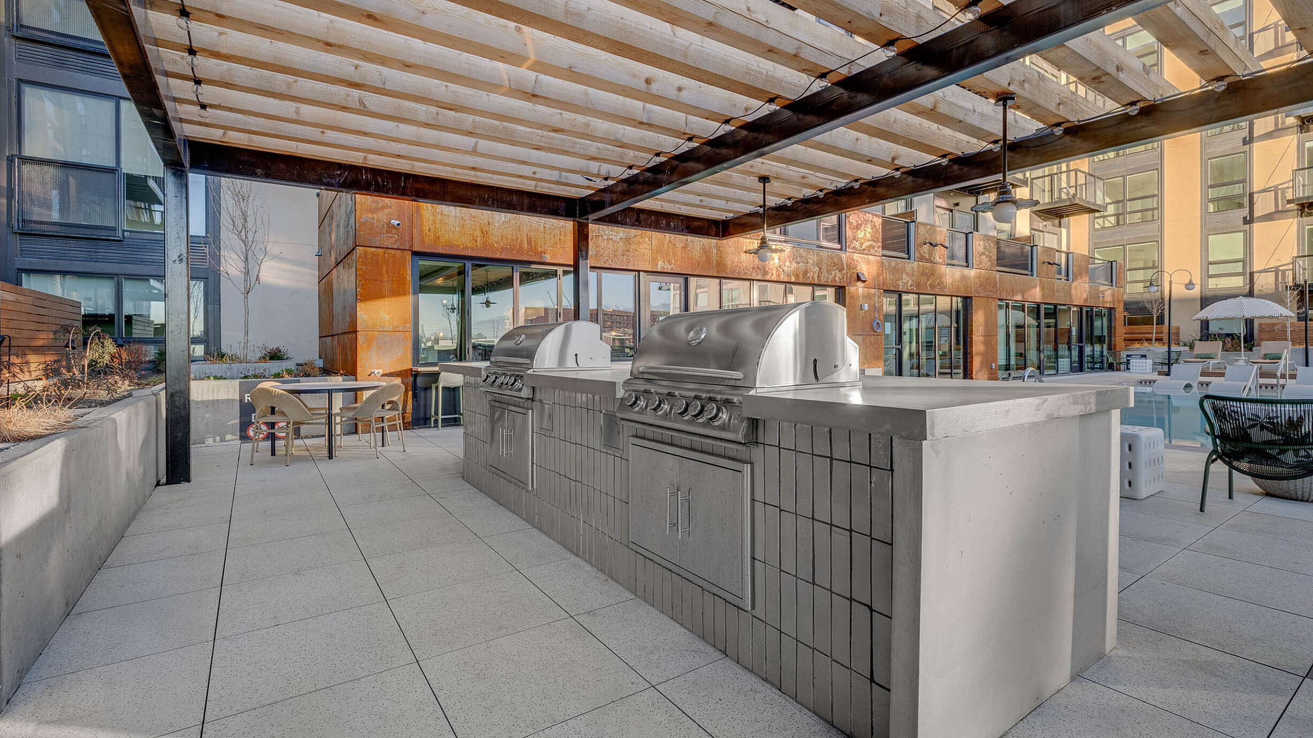 Chic outdoor patio with modern grills and a stylish pergola, perfect for entertaining and dining al fresco in a sophisticated urban setting.