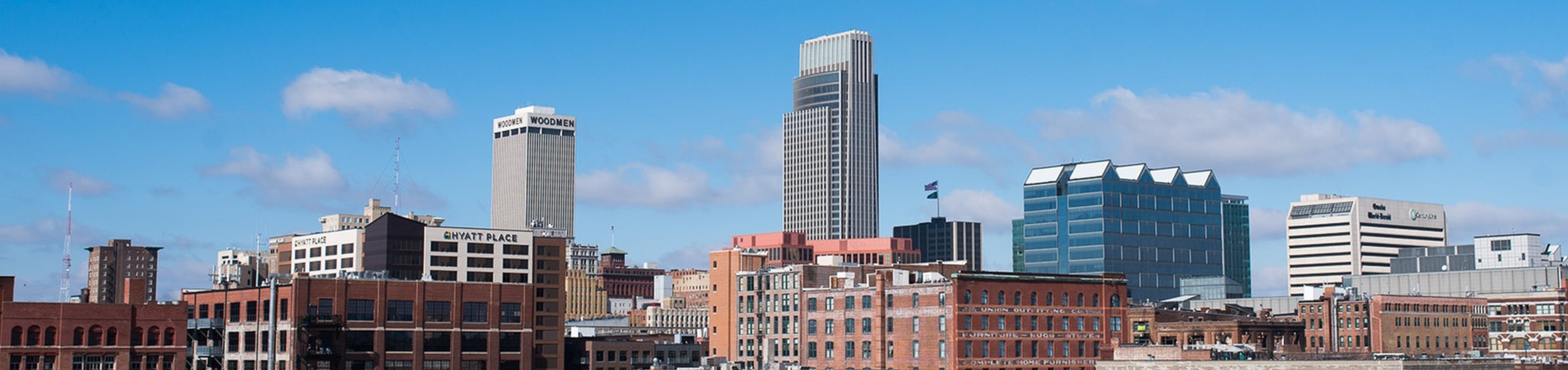 Vibrant cityscape with modern skyscrapers and charming brick buildings under a bright blue sky.