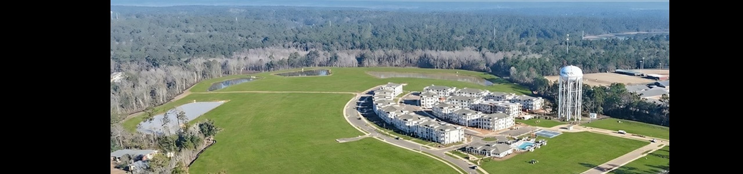 Expansive aerial view of modern residential complex with lush green surroundings and spacious layout.