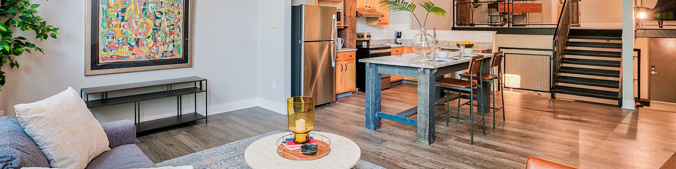 Chic industrial-style loft with exposed wooden beams, cozy living area, modern kitchen, and stylish decor.
