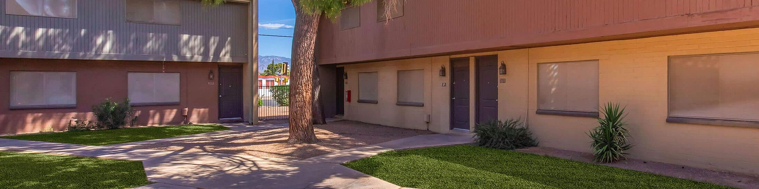 Charming two-story apartment complex with well-maintained exterior and lush greenery, offering a serene living environment.