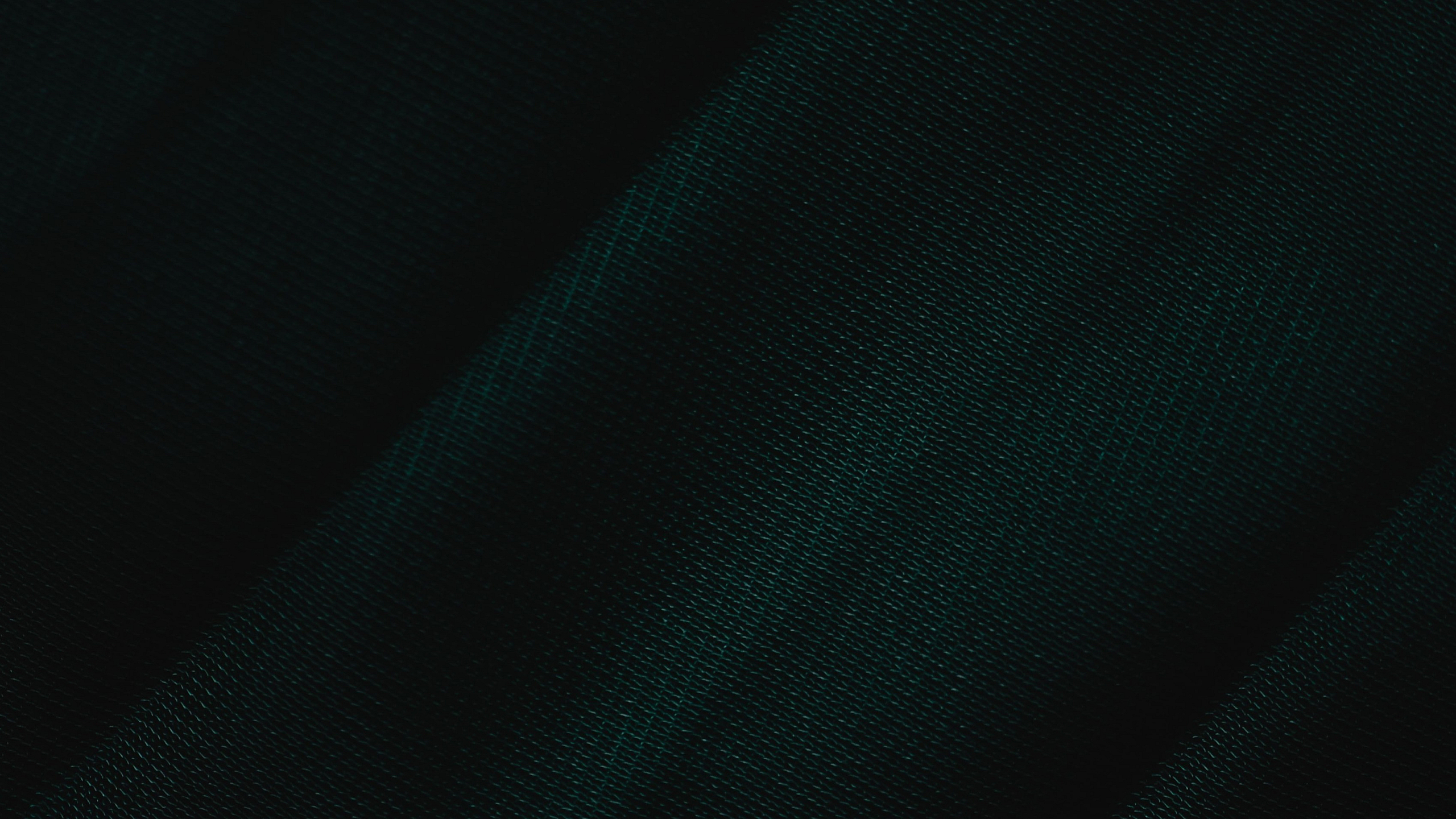 Elegant close-up of dark green textured fabric, showcasing its rich color and fine weave.