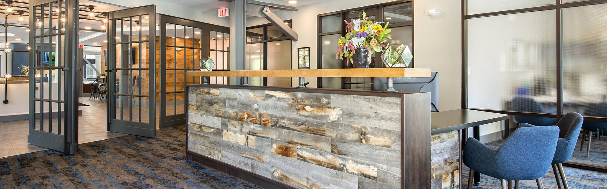 Modern and inviting lobby with stylish wood accents, elegant lighting, and comfortable seating, perfect for welcoming guests.