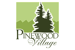 Elegant Pinewood Village logo featuring stylized pine trees against a serene green mountain backdrop, conveying a sense of tranquility and natural beauty.