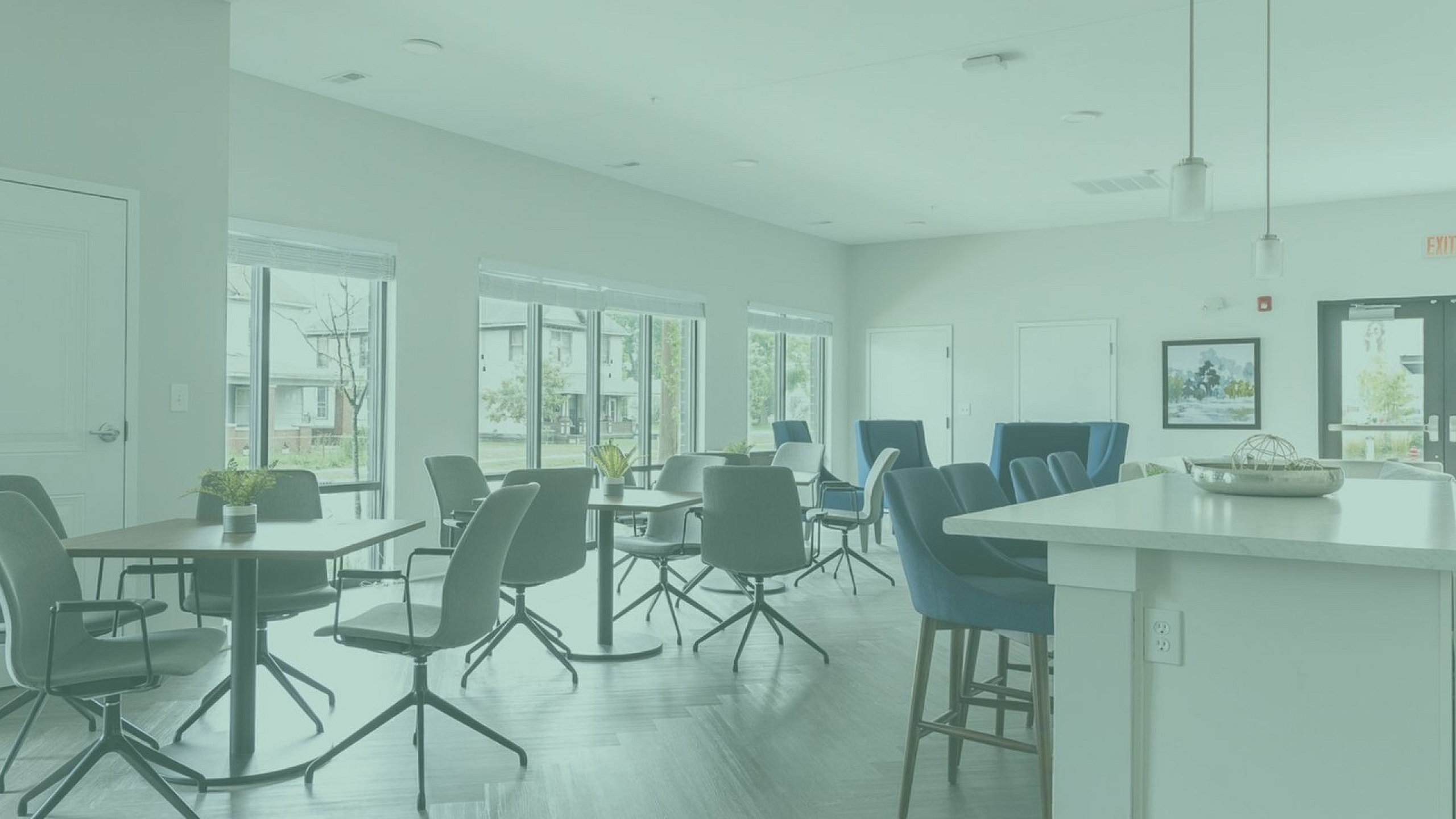 Bright and modern lounge area with stylish chairs, large windows, and a chic countertop, perfect for social gatherings.