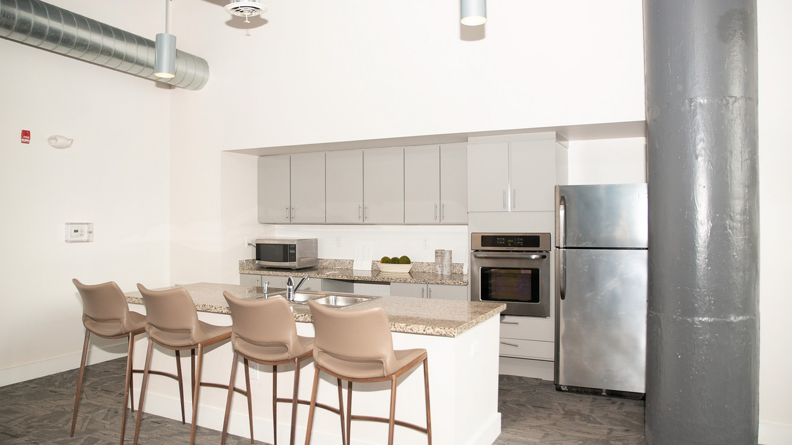 Contemporary kitchen featuring sleek cabinetry, stainless steel appliances, and a chic breakfast bar with stylish seating.
