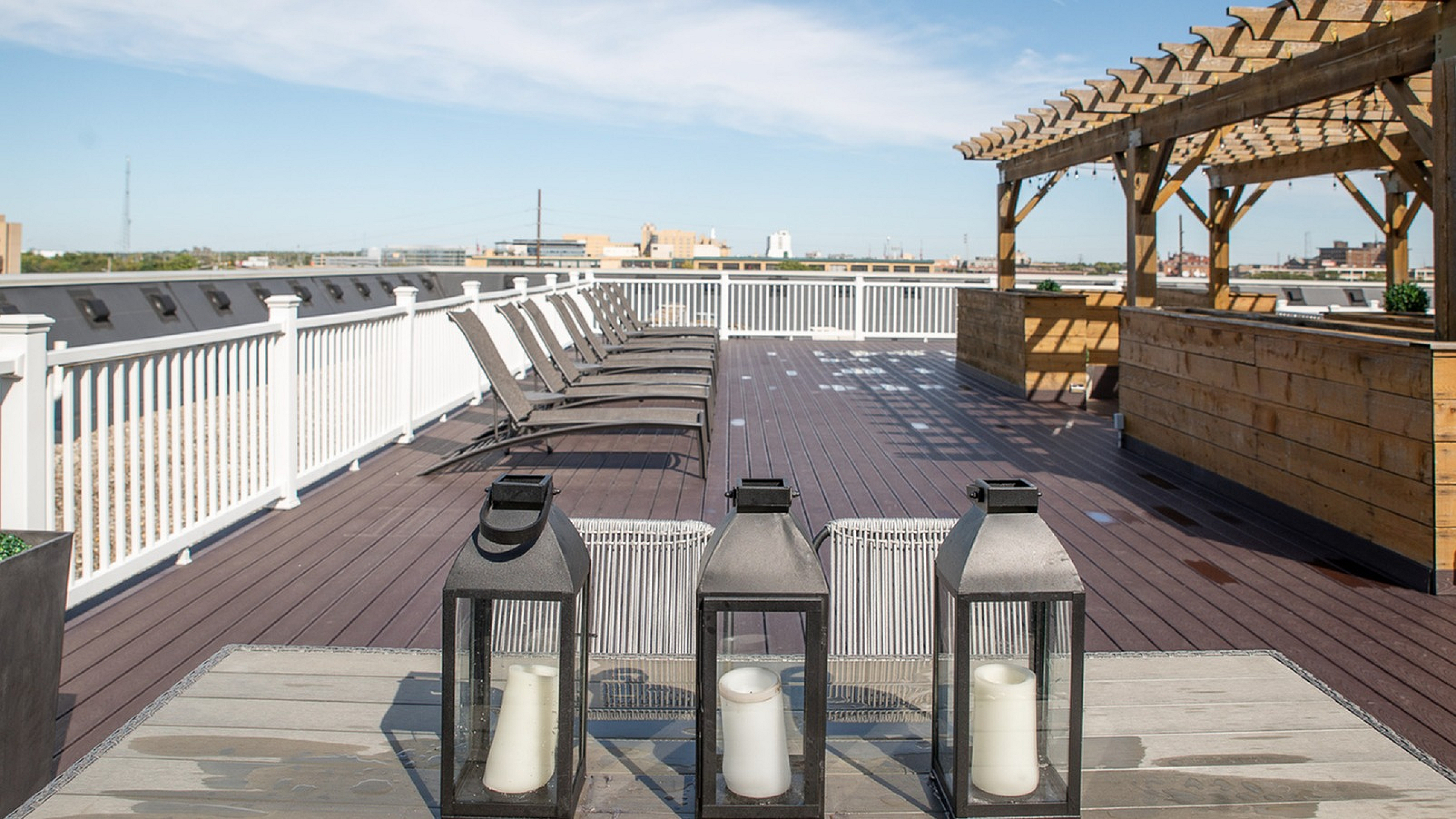 Chic rooftop terrace with stylish pergola, modern seating, and city views, perfect for relaxing under sunny skies.
