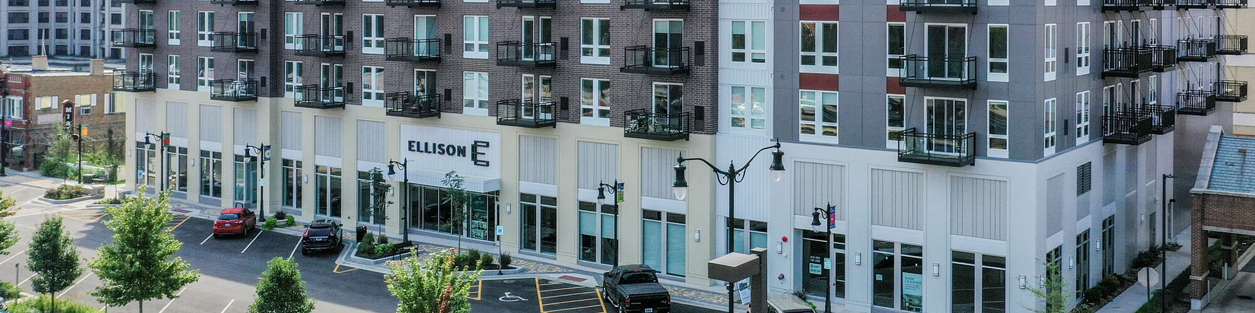 Modern urban apartment building with stylish balconies, large windows, and convenient street parking.