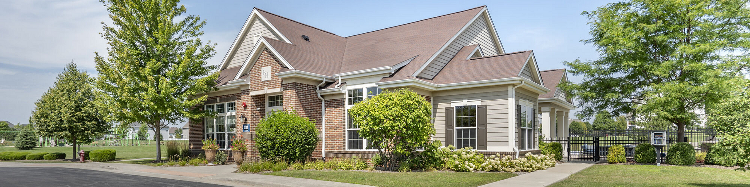 Charming brick and siding home with lush landscaping and a welcoming exterior, nestled in a serene neighborhood.
