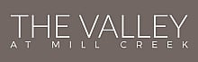 Elegant logo for The Valley at Mill Creek with sleek typography on a stylish gray background.