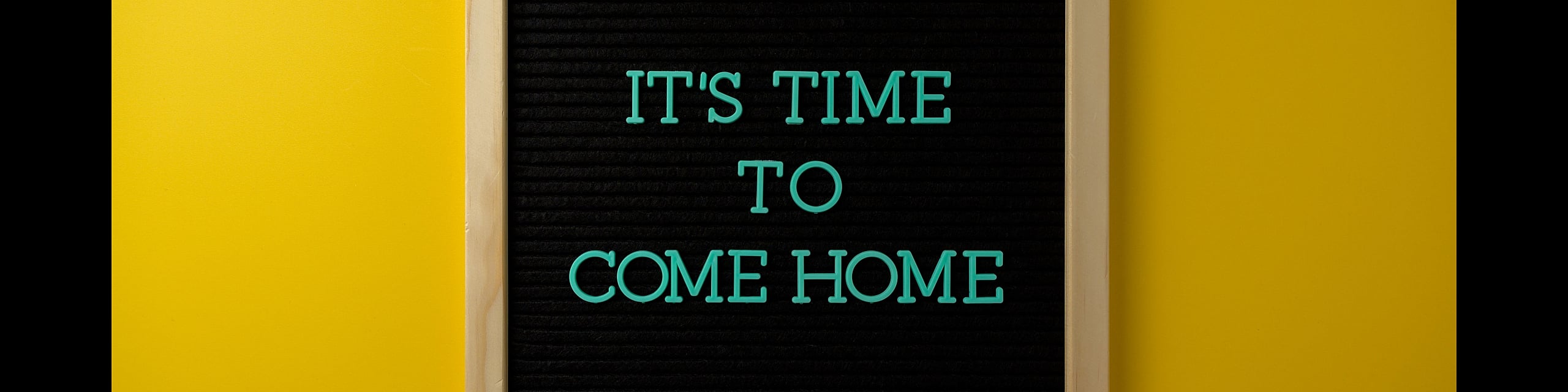 Inviting sign with 'It's Time To Come Home' text on a vibrant yellow background, evoking warmth and belonging.
