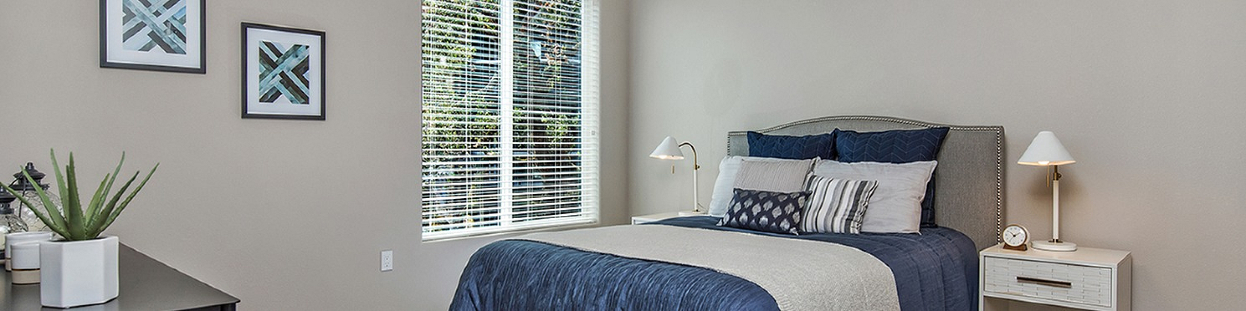 Elegant bedroom with a cozy bed, modern decor, and large window flooding natural light.