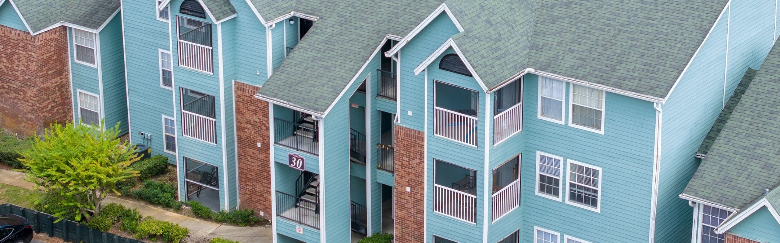 Charming and colorful apartment complex with spacious balconies and lush greenery.