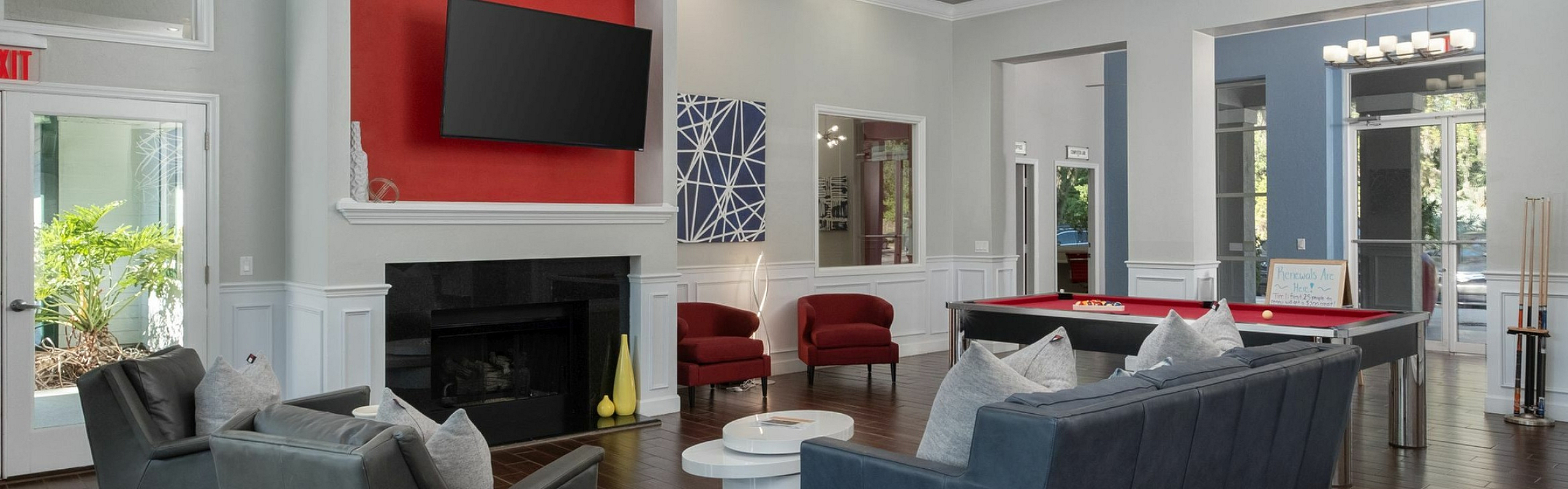 Elegant communal lounge featuring modern seating, a sleek fireplace, and a stylish pool table under ambient lighting.