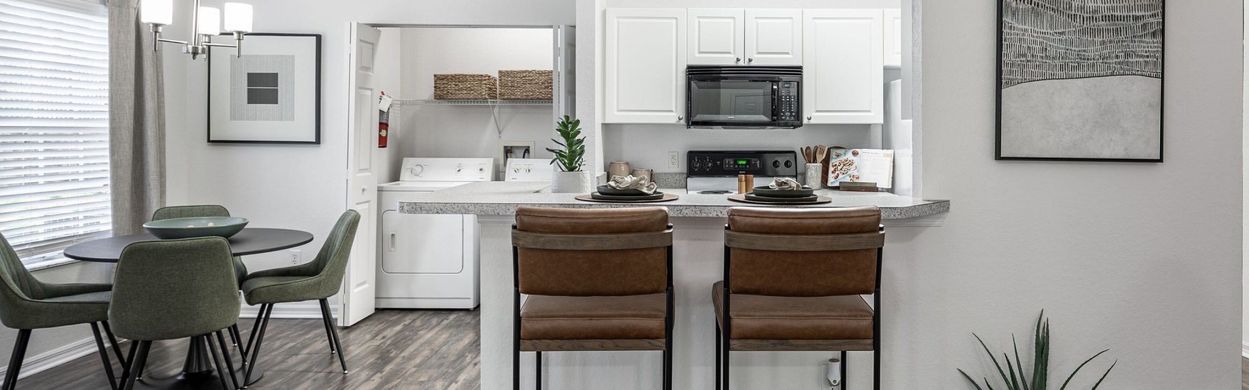 Chic and modern open-concept apartment with stylish kitchen, cozy dining area, and hardwood floors, perfect for urban living.
