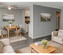 Contemporary living and dining area with elegant decor, featuring a cozy seating arrangement, stylish wooden furniture, and tasteful artwork.