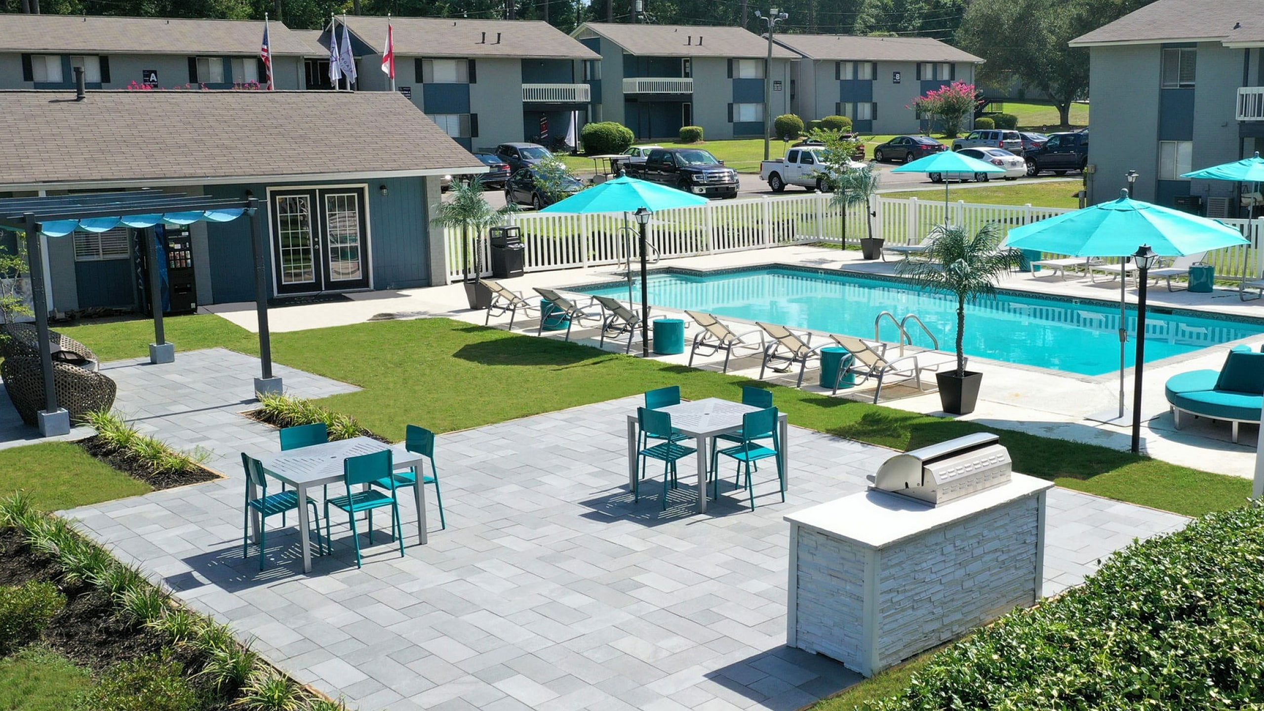 Inviting outdoor pool area with modern seating and umbrellas in a residential complex.