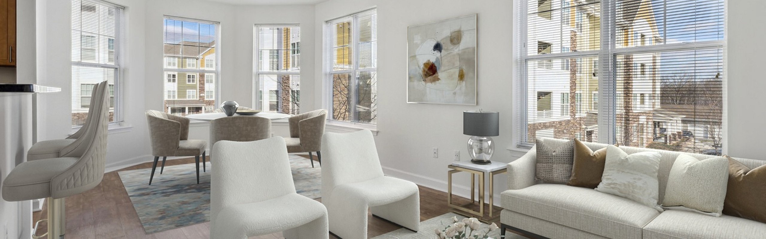 Bright and spacious modern apartment living room with large windows, elegant seating area, stylish marble coffee table, and dining space, perfect for entertaining.