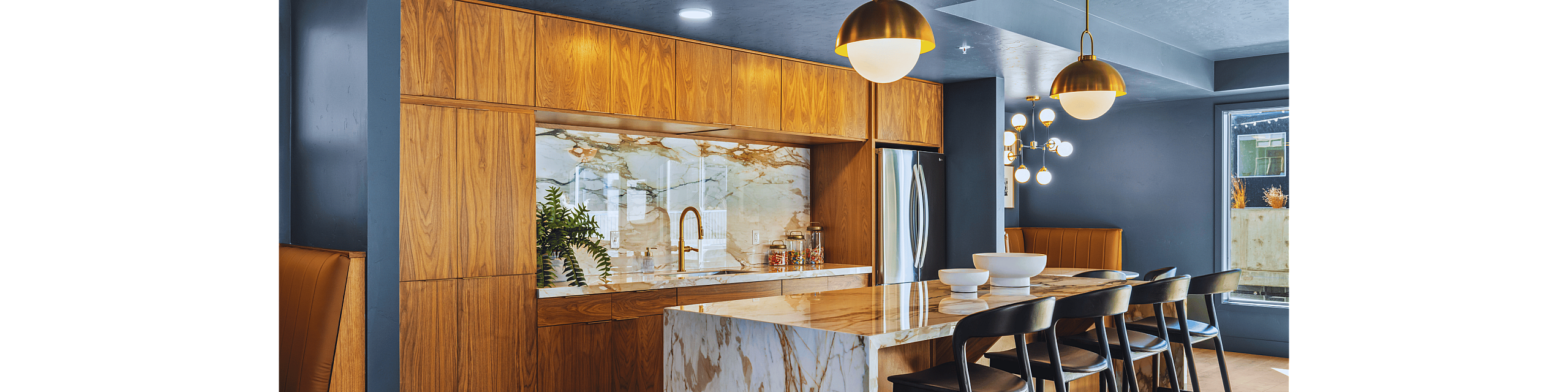 Modern kitchen with marble countertop, elegant pendant lighting, and wooden accents