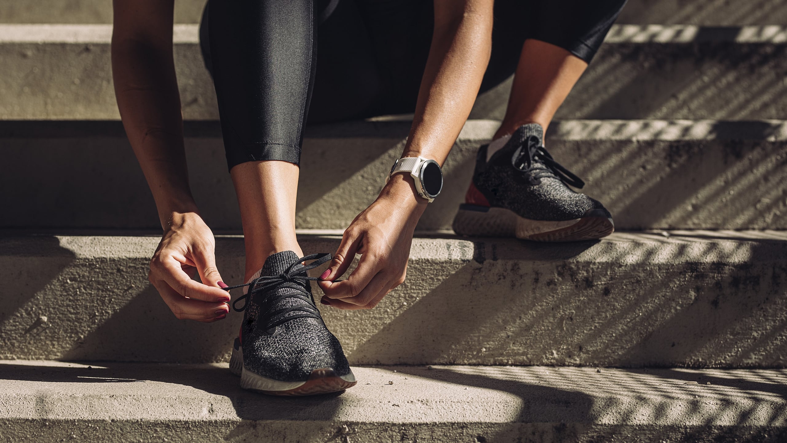 Dynamic close-up of a person tying shoelaces on athletic sneakers, embodying a readiness for fitness and outdoor adventure.