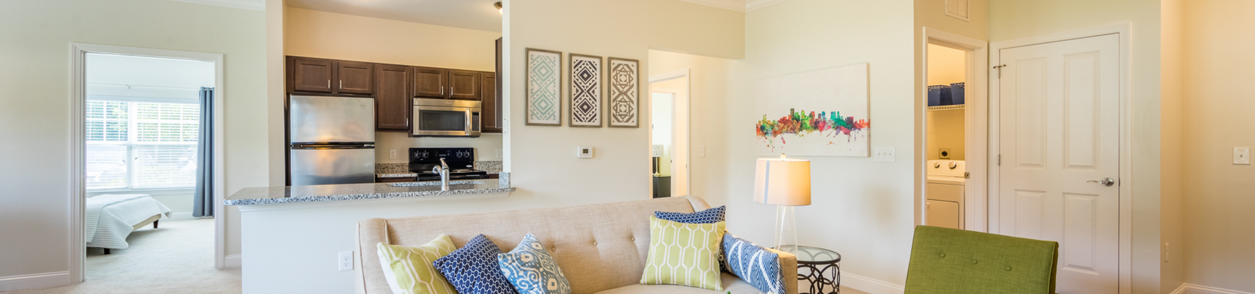 Bright and modern living area with cozy seating, stylish decor, and contemporary kitchen, showcasing an open, inviting layout.