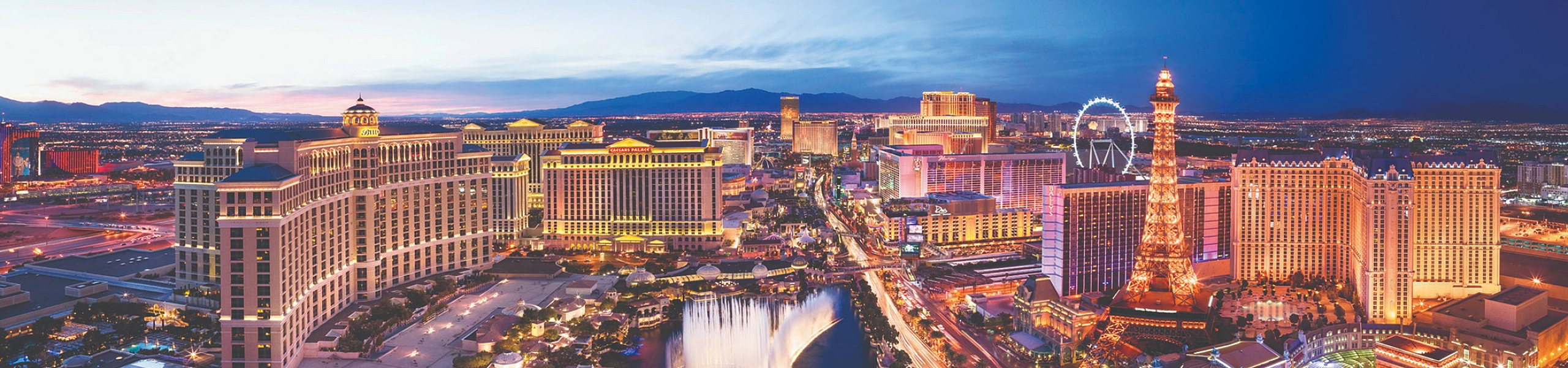 Breathtaking panorama of a vibrant cityscape with dazzling lights, iconic landmarks, and a stunning water fountain display, set against a twilight sky.