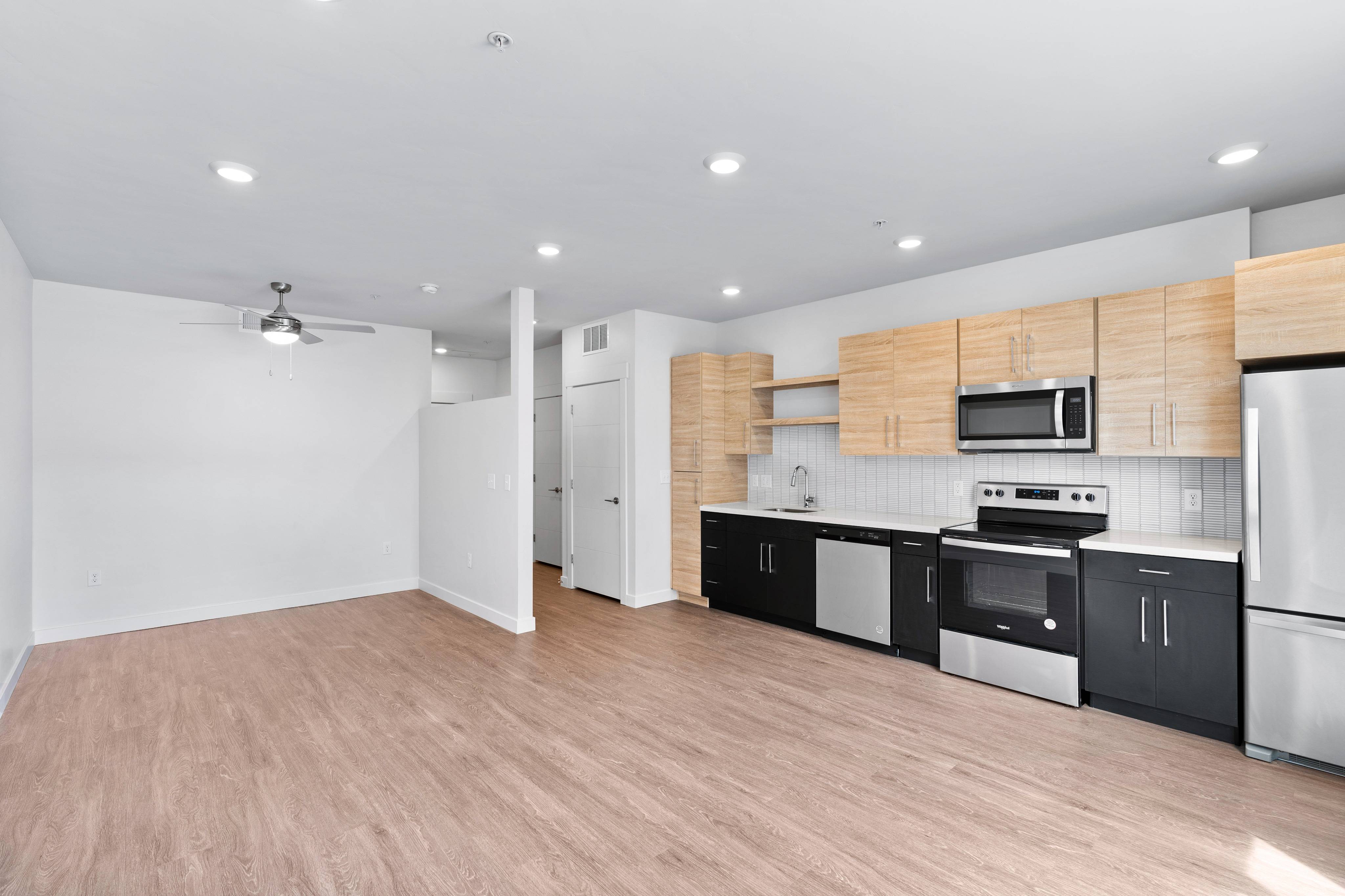 View of Plank Wood Flooring in Studio Apartment Showing Two-Tone Wood and Black Cabinets
