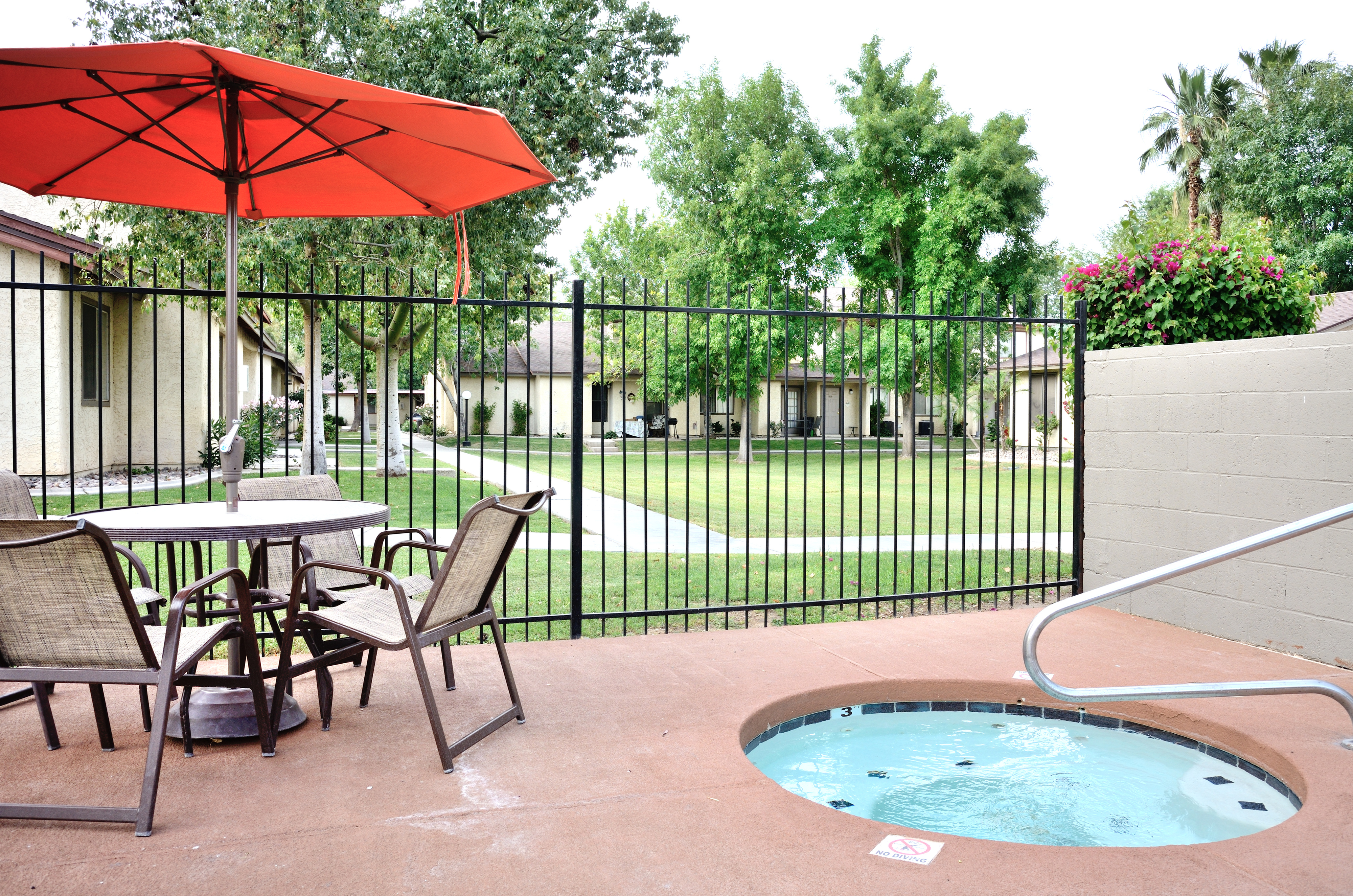 View of Hot Tub, Showing Seating Area With Umbrella at Camelot Apartments