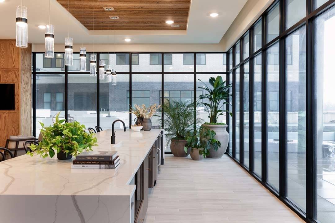 Large entertaining island surrounded by glass walls looking out over pool deck