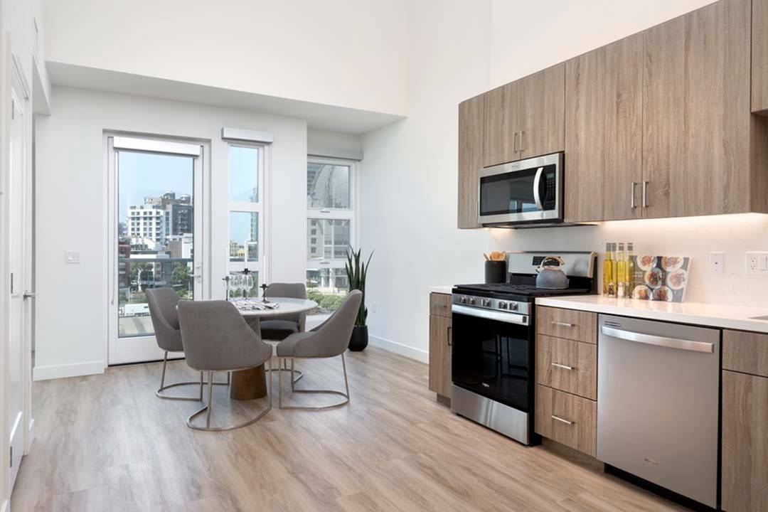 Gallery-style kitchen in loft featuring white quartz countertops with matching backsplashes