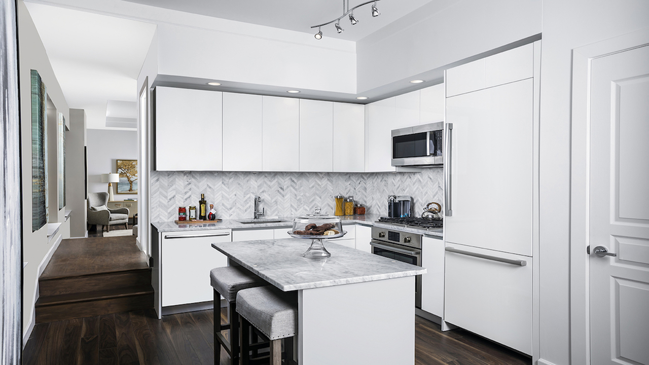 Opulent Open Concept Kitchen with White Cabinetry and Marble Countertops