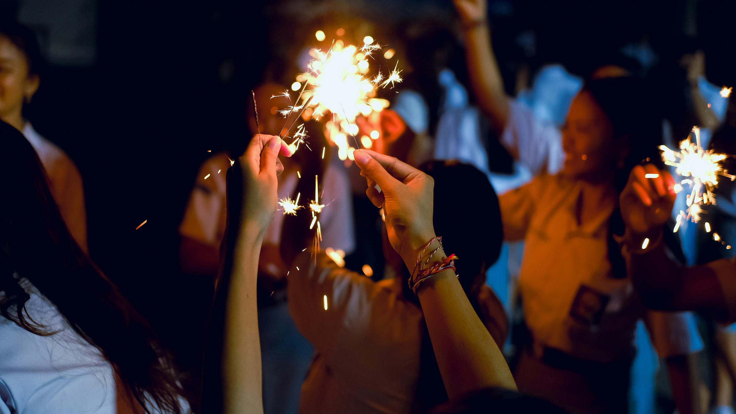 Vibrant celebration with people holding sparklers, creating a joyful and festive atmosphere.